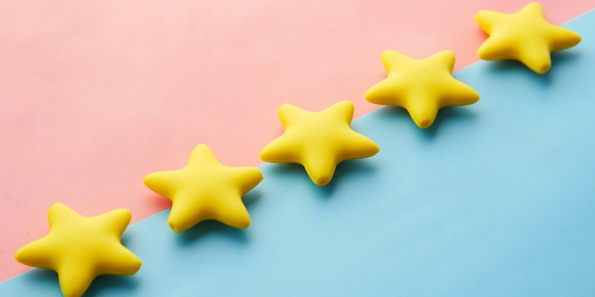 a row of yellow stars sitting on top of a blue and pink surface